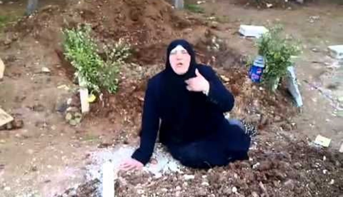 أمٌّ تُخرِجُ ابنها من القبر