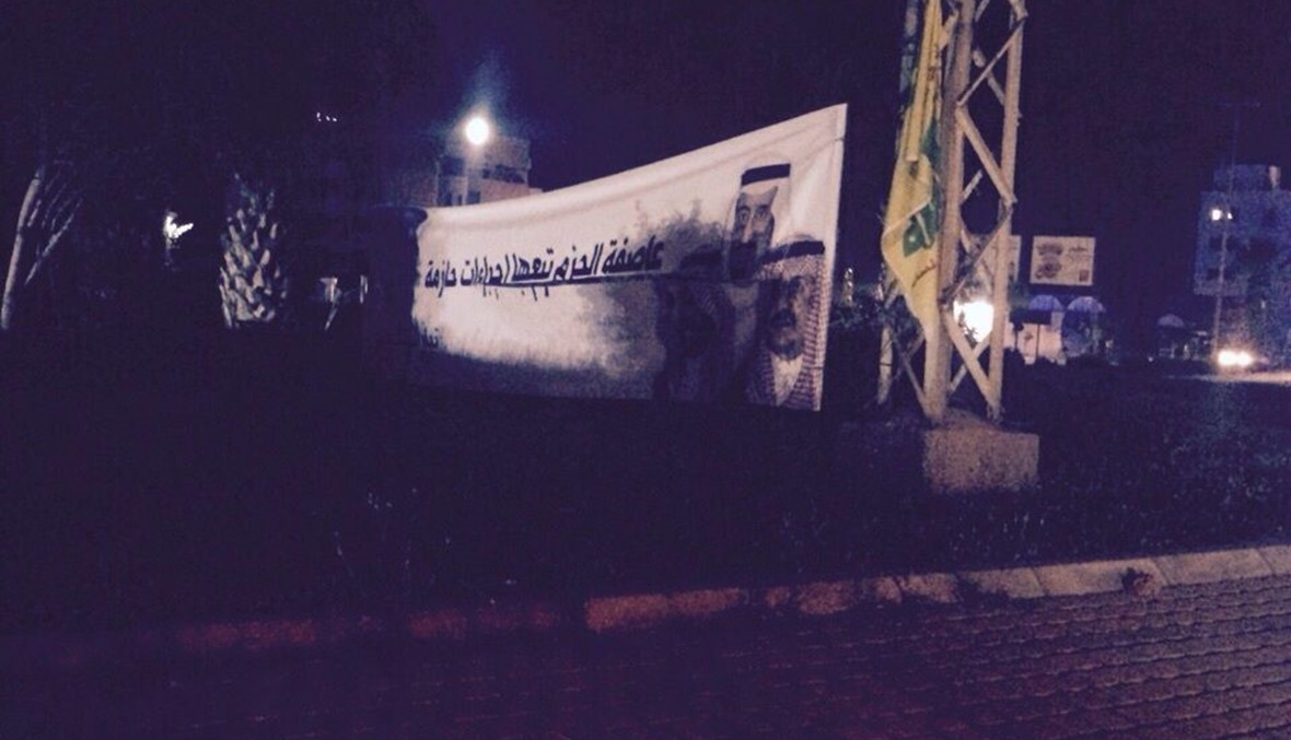 مجهولون يمزقون لافتة للملك السعودي في صيدا ويرفعون علم "حزب الله" - بالصور