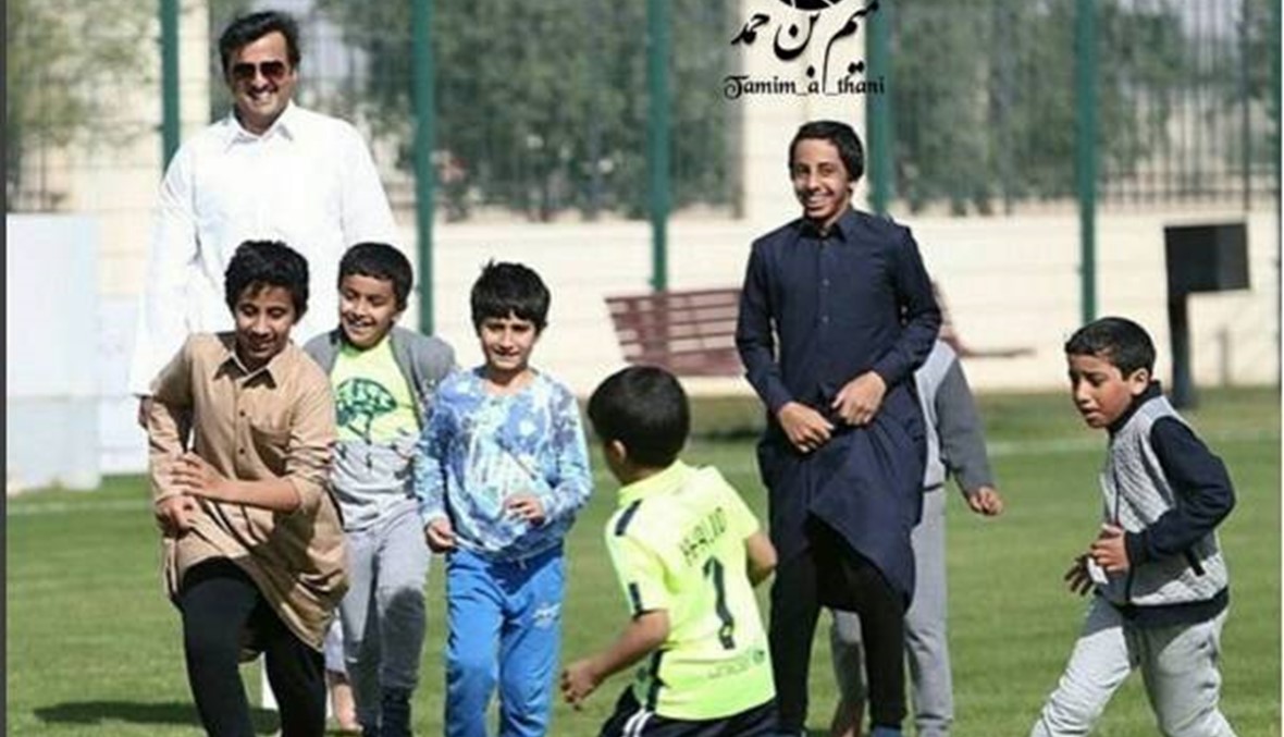 بالصور- أمير قطر يلعب كرة القدم مع الأطفال "حافي القدمين"