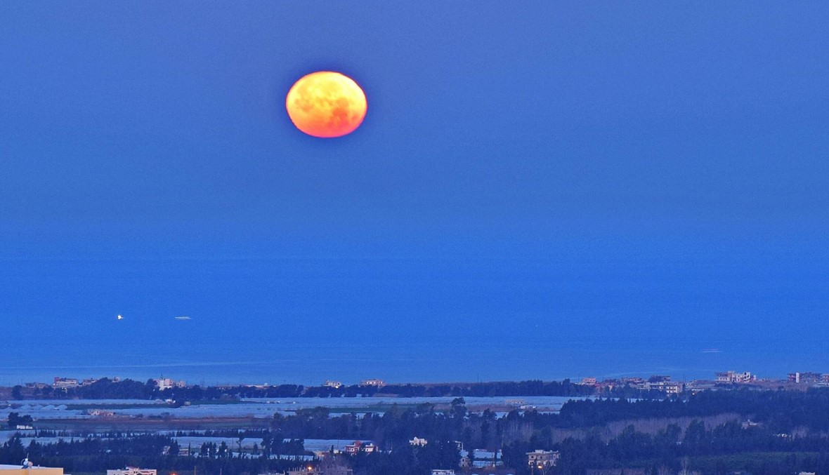 صور رائعة للقمر الناري في لحظات انغماسه خلف مياه المتوسط!