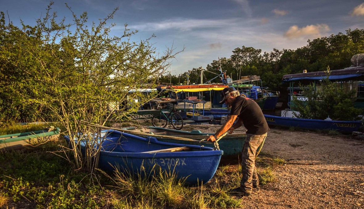 صياد كوبي يضع قارب صيده في مكان آمن قبل وصول إعصار إيرما (الصورة نقلاً عن أ.ف.ب)