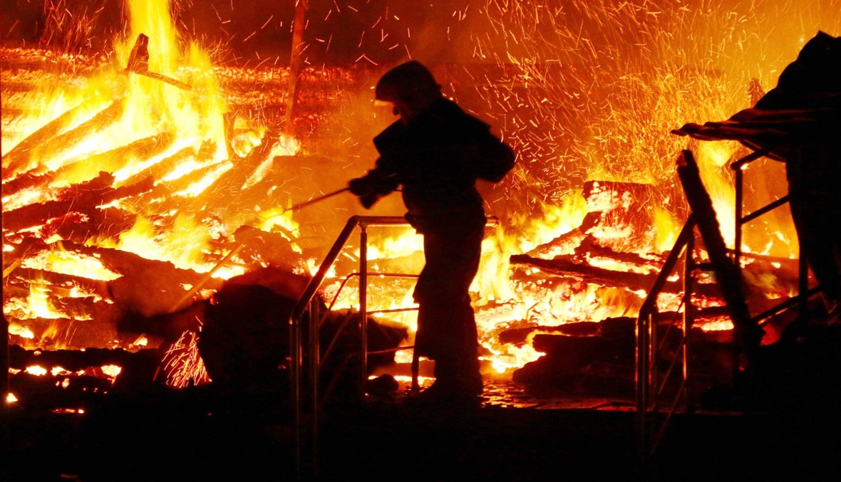 رجال اطفاء يحاولون اخماد حريق اندلع داخل مخيم في اوكرانيا تسبب بوفاة 3 اطفال (الصورة نقلاً عن أ. ف. ب )