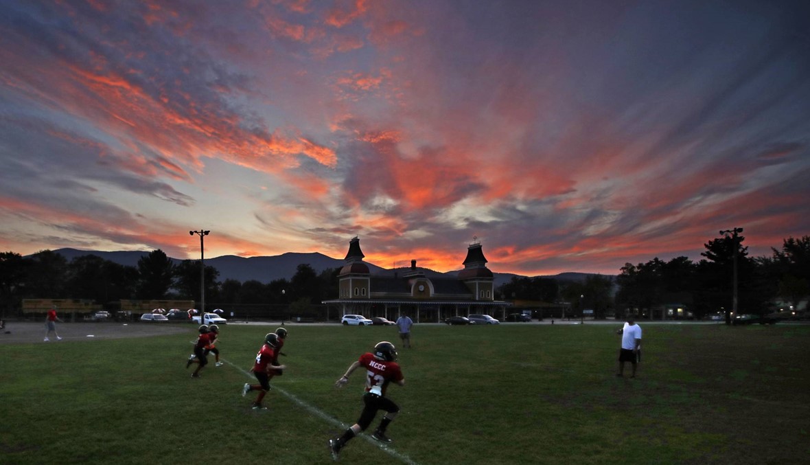 لاعبون يمارسون لعبة كرة القدم الأميركية في شمال البلاد أثناء غروب الشمس (أ ب)