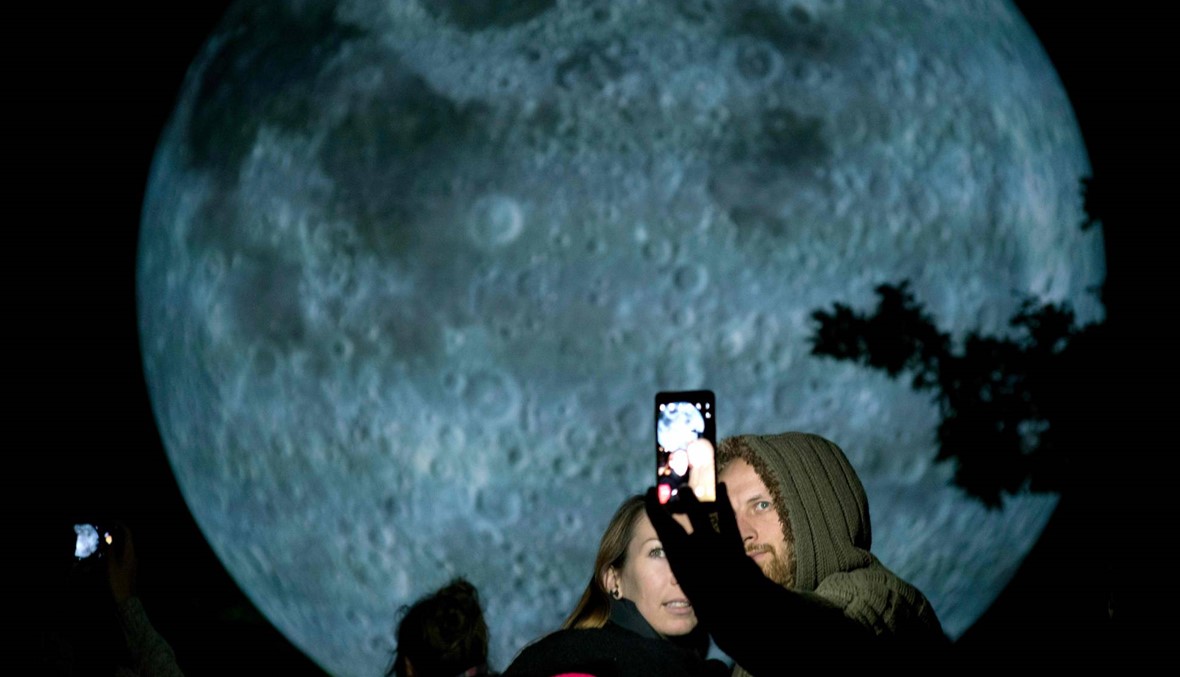 زوجان يلتقطان "السِلفي" في متحف القمر للفنان لوك جيرام (أ ف ب)