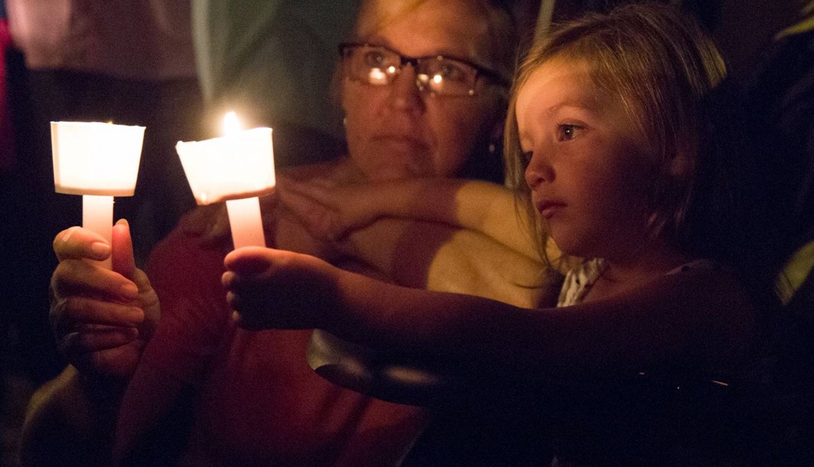 اضاءة شموع في تكساس بعد المجزرة بحق العشرات داخل الكنيسة (أ ف ب).