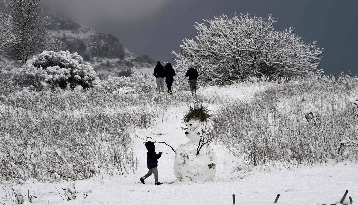 طفل يلهو بالقرب من رجل الثلج في مارسيليا الفرنسية (أ ف ب).
