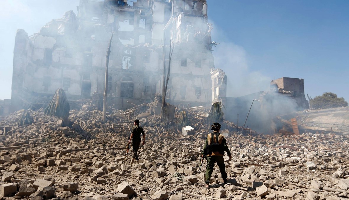 مقاتلون حوثيون يتفقدون الدمار بعد غارات جوية استهدفت القصر الرئاسي في صنعاء. (أ ف ب)