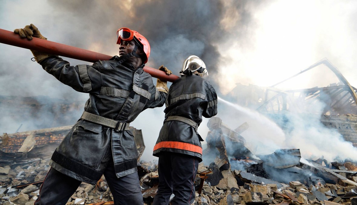 رجال الاطفاء في أبيدجان يحاولون السيطرة على حريق في أحد معامل الطلاء يملكه رجل أعمال لبناني. (أ ف ب)