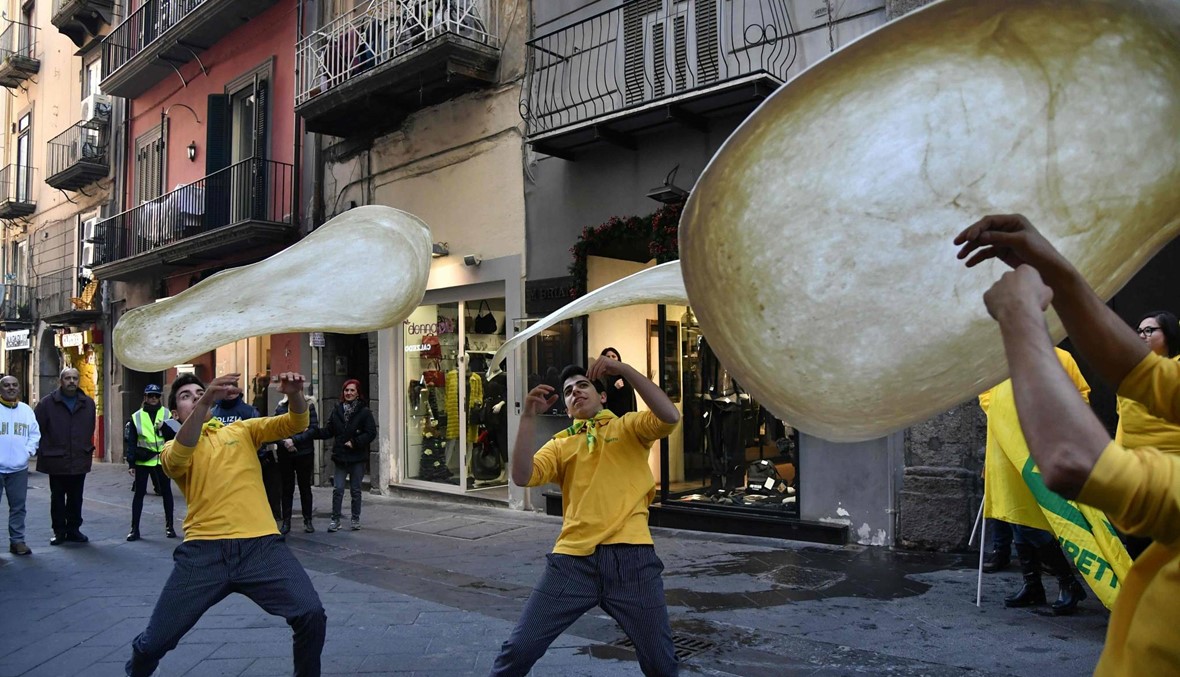 احتفالات في نابولي بقرار "الأونيسكو" إدخال فنّ صناعة البيتزا في قائمة التراث غير المادّي للبشرية (أ ف ب).