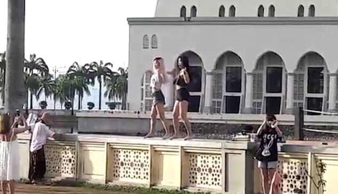 "رقصة مثيرة" لزائرتين أمام مسجد ماليزي... "سلوك غير مقبول" (فيديو)