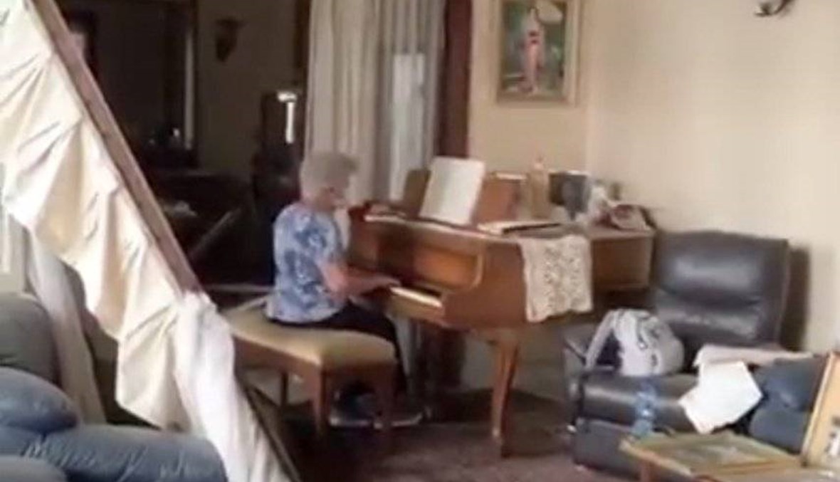 من بين الركام والدمار... امرأة مسنّة تواجه الواقع الأسود بالموسيقى (فيديو)