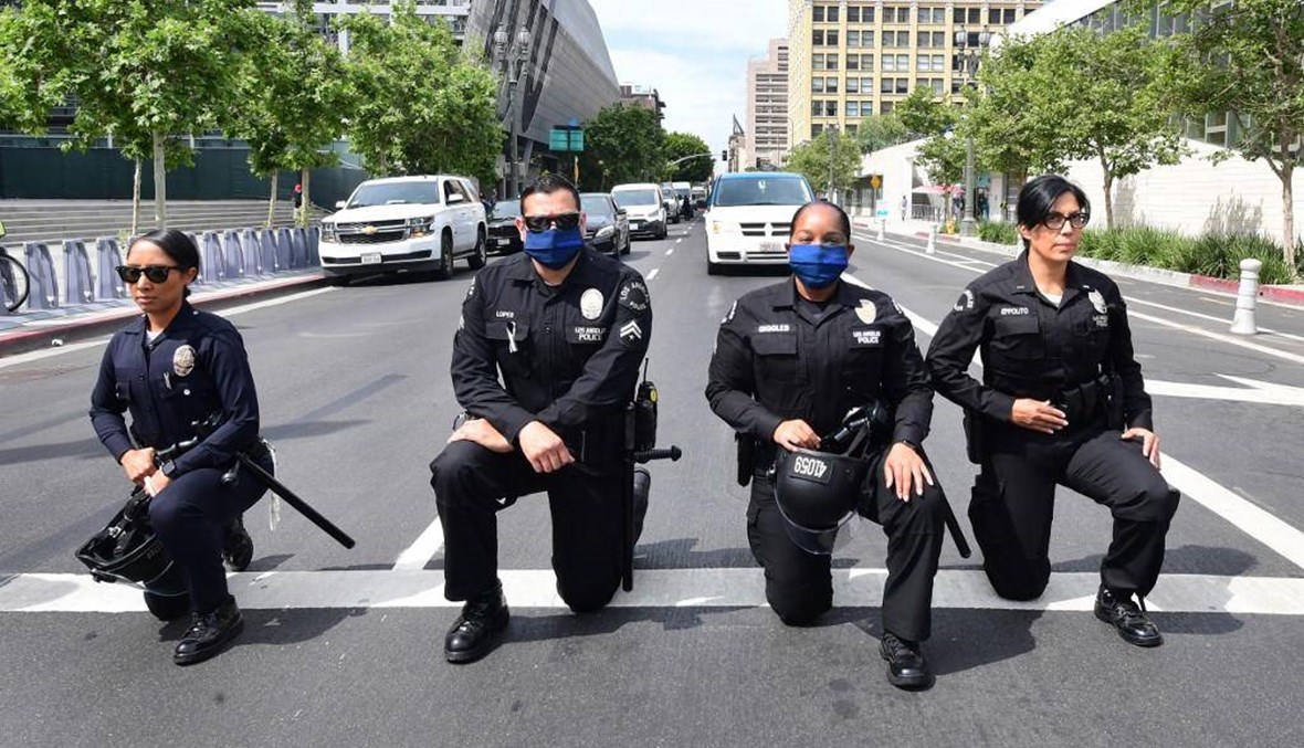 شرطيون أميركيون يركعون على ركبة واحدة دعماً للمحتجين: السلاح رُفِع إلى أعلى