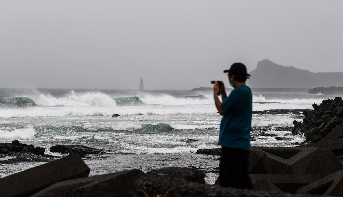 رجل يلتقط صوراً على الشاطئ في ماكورازاكي بمحافظة كاجوشيما، مع اقتراب إعصار هايشن (6 أيلول 2020، أ ف ب).