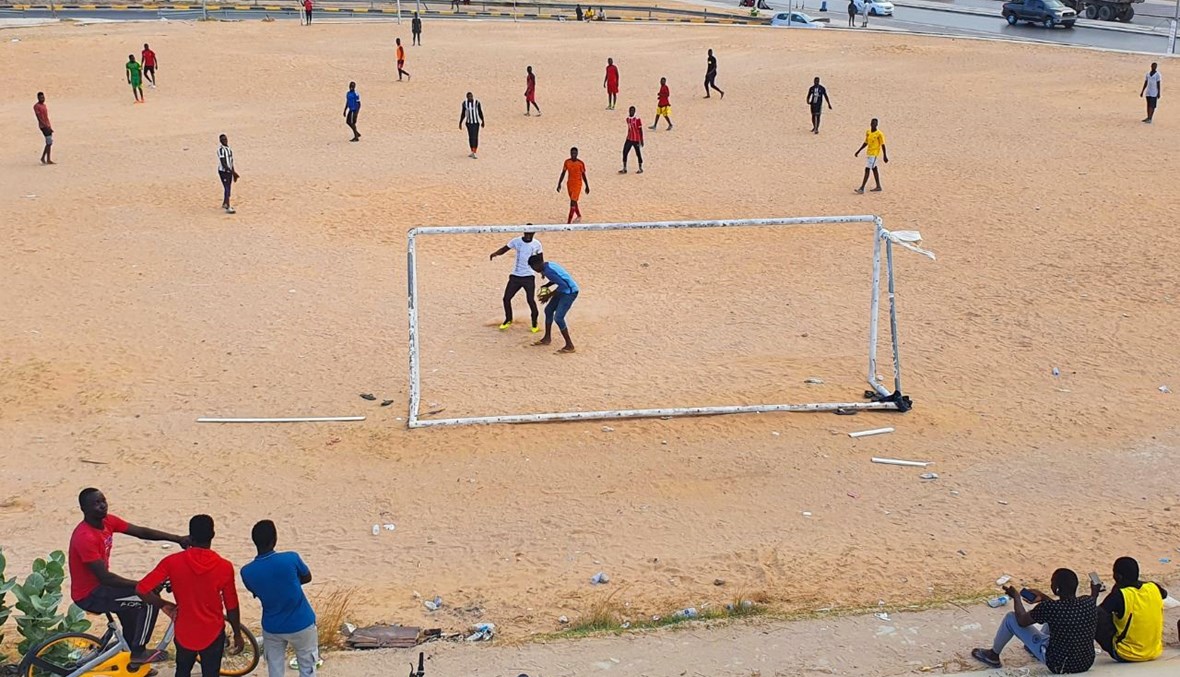 شباب يلعبون كرة القدم في ملعب رملي في طرابلس (5 أيلول 2020، أ ف ب).