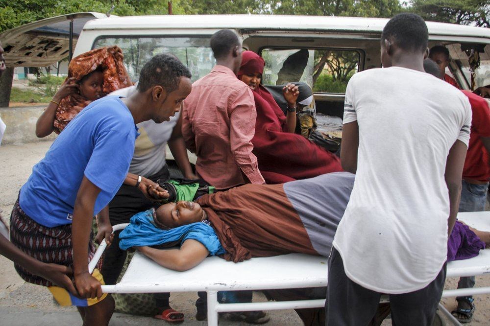 مسعفون ينقلون امرأة أصيبت في انفجار سيارة مفخخة في مقديشو (16 آب 2020، أ ب).