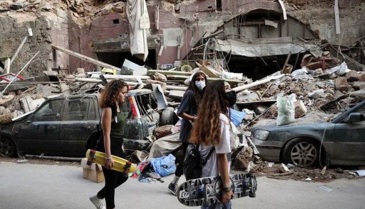 Women walk past destroyed cars at a neighborhood near the scene of Tuesday's explosion that hit the seaport of Beirut, Lebanon, Friday, Aug. 7, 2020. (AP Photo)