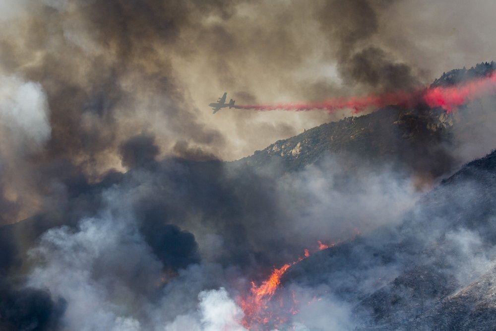In this Saturday, Sept. 5, 2020 file photo, an air tanker drops fire retardant on a hillside wildfire in Yucaipa, Calif. (AP Photo)