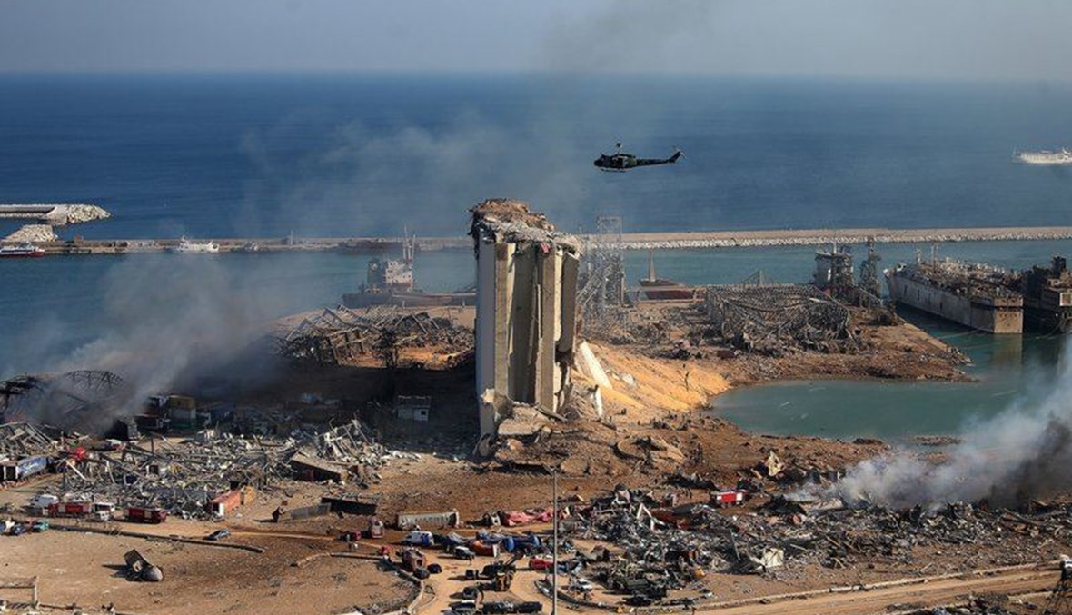 A helicopter hovers over damaged grain silos in Beirut's port. (AFP)