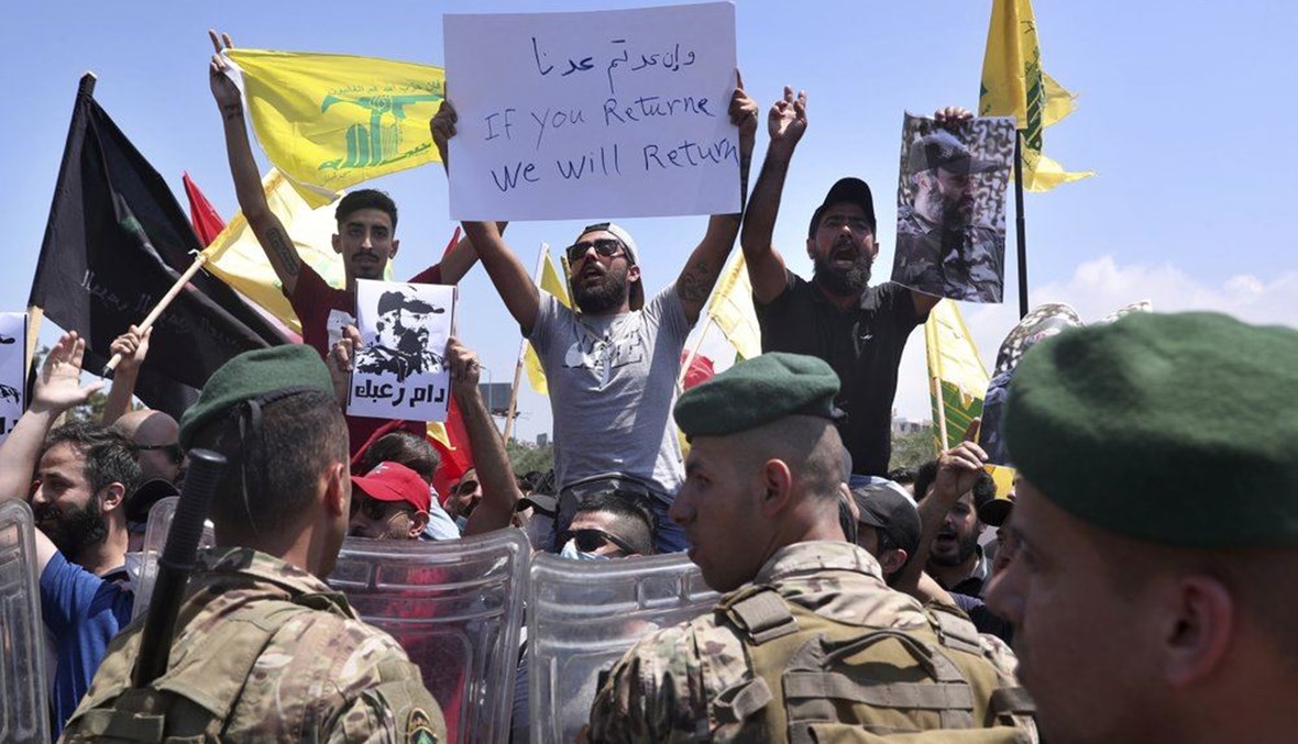 Lebanese army soldiers stand guard as Hezbollah supporters chant slogans and hold posters of the late Hezbollah military commander Imad Mughniyeh,  in Beirut, Lebanon, Wednesday, July 8, 2020. (AP Photo)
