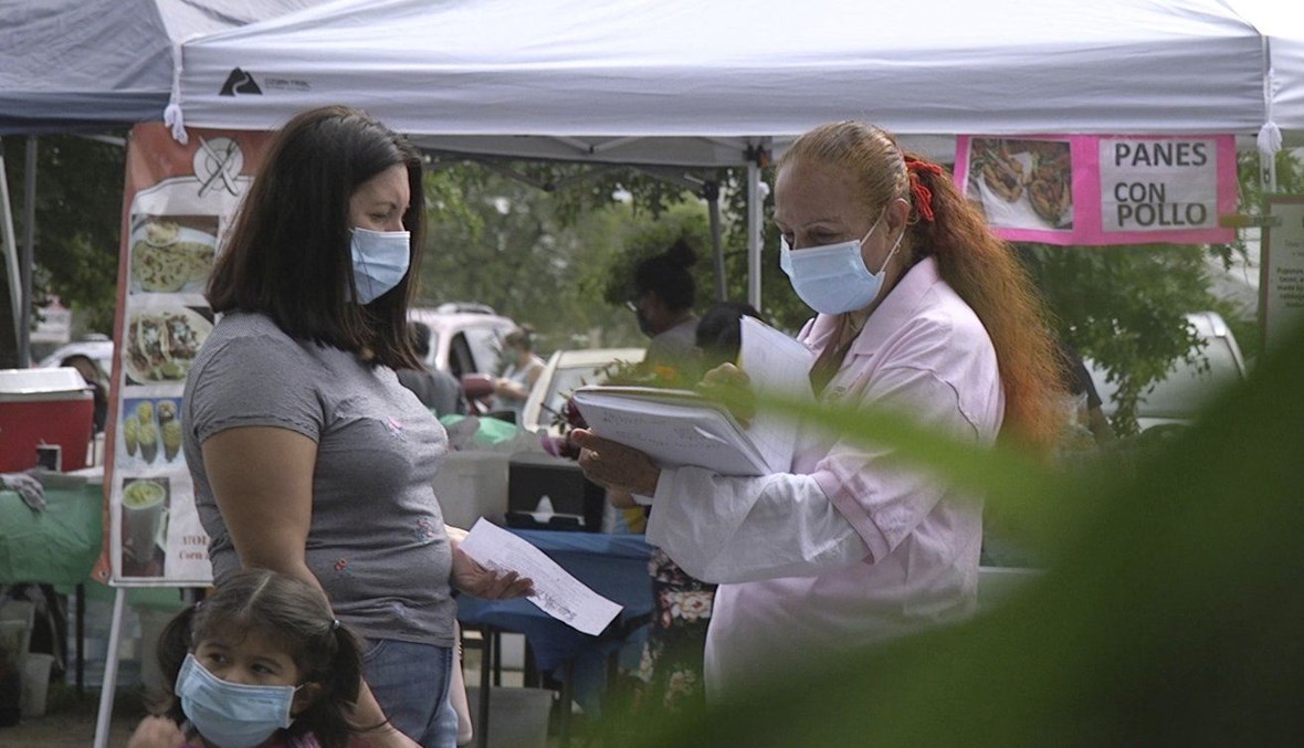 A "promotora" (health promoter) from CASA, a Hispanic advocacy group, tries to enroll Latinos as volunteers to test a potential COVID-19 vaccine, at a farmers market in Takoma Park, Md., on Sept. 9, 2020. (AP Photo)