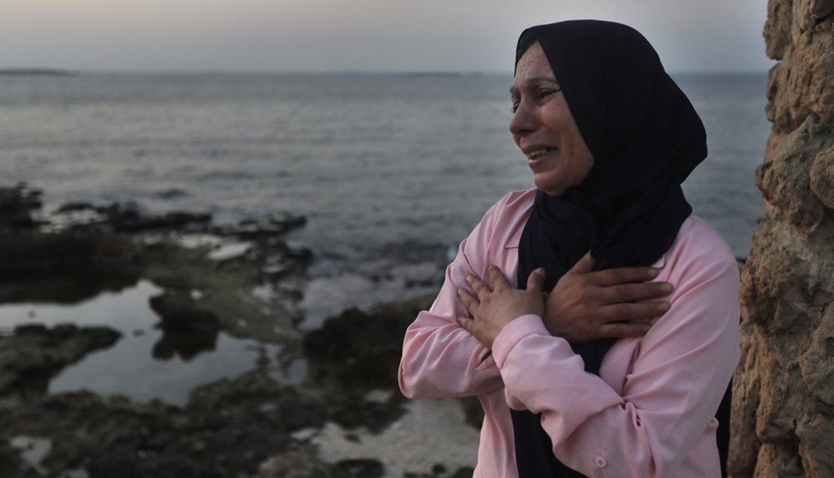 Lebanese Afaf Adulhamid the mother of Mohammed Khaldoun, 27, who is still missing at sea while he was trying with other migrants to reach Cyprus on a boat, cries and prays her son's safe return, as she stands on the coast of Tripoli city, north Lebanon Thursday, Sept. 17, 2020. (AP Photo)