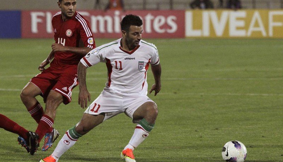 This Tuesday, June 11, 2013 file photo, Iran's Gholam Reza Rezaei, foreground, plays the ball, as he is followed by Mohamad Atwi, of Lebanon, in their Asian qualifiers soccer match for 2014 World Cup, at the Azadi (Freedom) stadium in Tehran, Iran. (AP Photo)