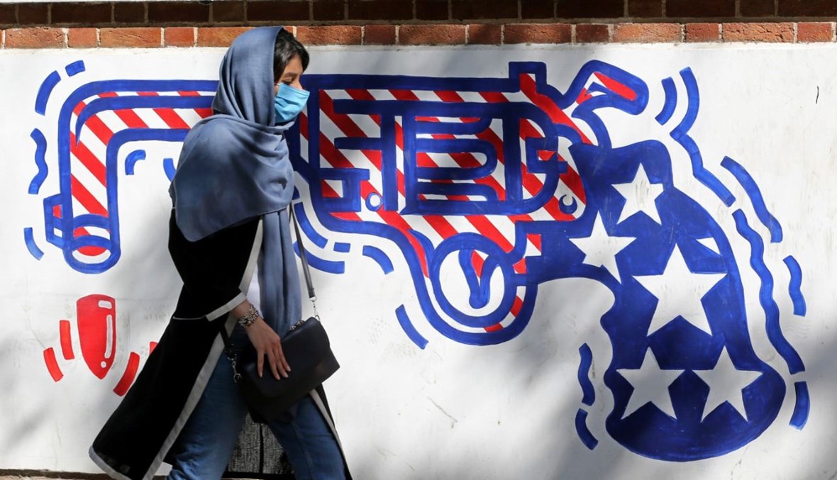 امرأة تمر بالقرب من جدارية مرسومة على الجدران الخارجية للسفارة الأميركية السابقة في طهران (20 أيلول 2020، أ ف ب). 