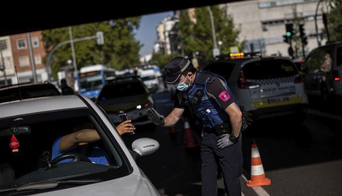A local police stops a vehicle at a checkpoint in Madrid, Spain, Monday, Sept. 21, 2020. (AP Photo)