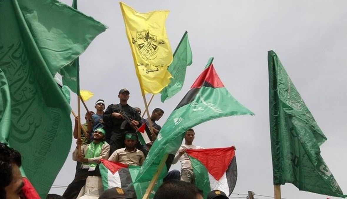 صورة من الارشيف لفلسطينيين يلوحون بأعلام "فتح" و"حماس" في مدينة غزة.