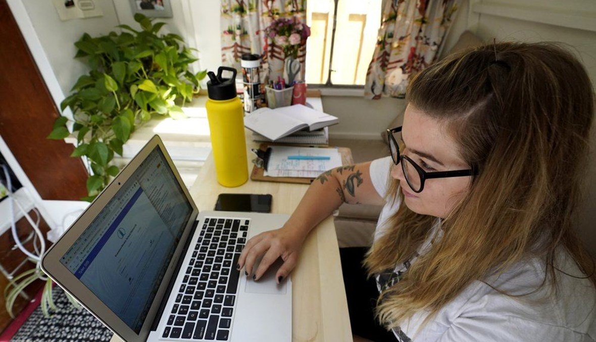 In this Wednesday, Sept. 2, 2020 file photo, Kelly Mack works on her laptop to teach remotely from her early 1940s vintage camper/trailer in her backyard at home in Evanston, Ill. (AP Photo)