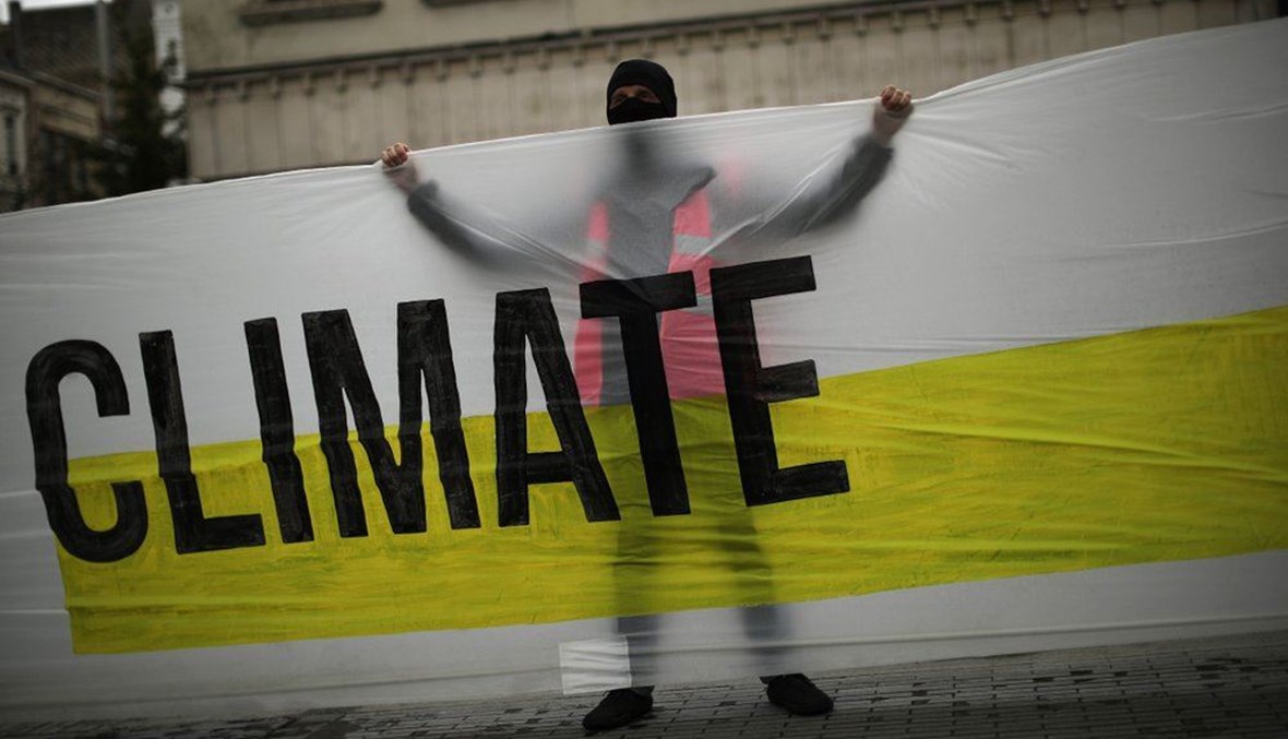 A man, wearing a mask to prevent the spread of the coronavirus, holds a banner that reads: "United for climate" during a small climate change protest in downtown Brussels, Friday, Sept. 25, 2020. (AP Photo)