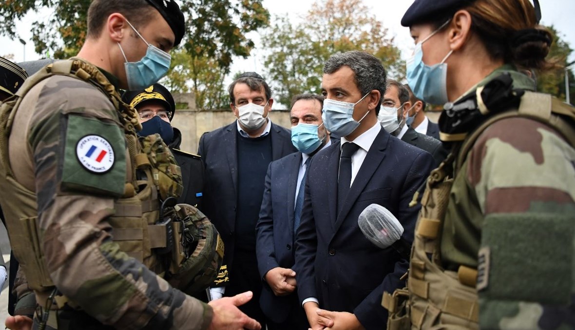 وزير الداخلية الفرنسي جيرالد دارمانان (في الوسط) يكلم جنديا خلال زيارة لكنيس بولونيو بيلانكور في ضواحي باريس (27 أيلول 2020، أ ف ب). 