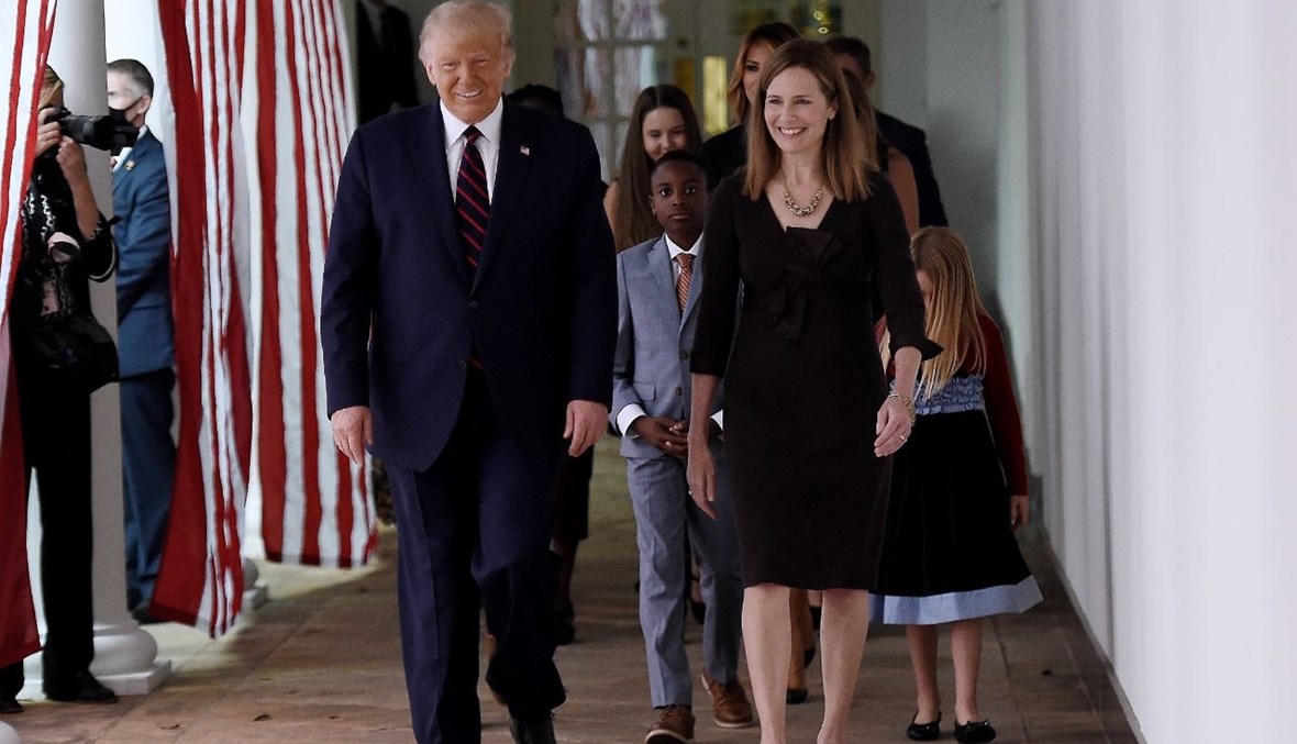 ترامب والقاضية آمي كوني باريت خلال توجههما إلى حديقة "روز غاردن" في البيت الأبيض (26 أيلول 2020، أ ف ب). 