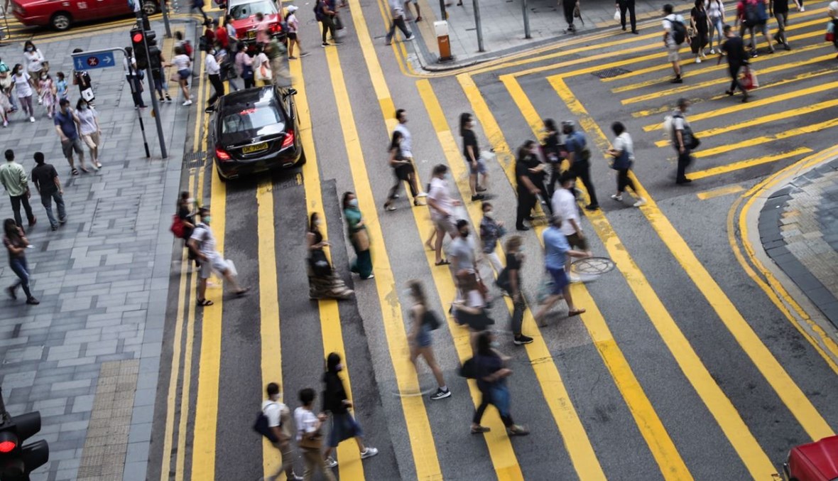 أشخاص يعبرون الشارع في المنطقة المركزية في هونغ كونغ (27 أيلول 2020، أ ف ب). 