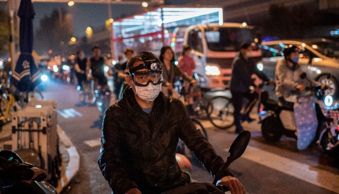 رجل يقود دراجته النارية خلال ساعة الذروة المسائية في أحد شوارع بيجينغ (28 أيلول 2020، أ ف ب). 