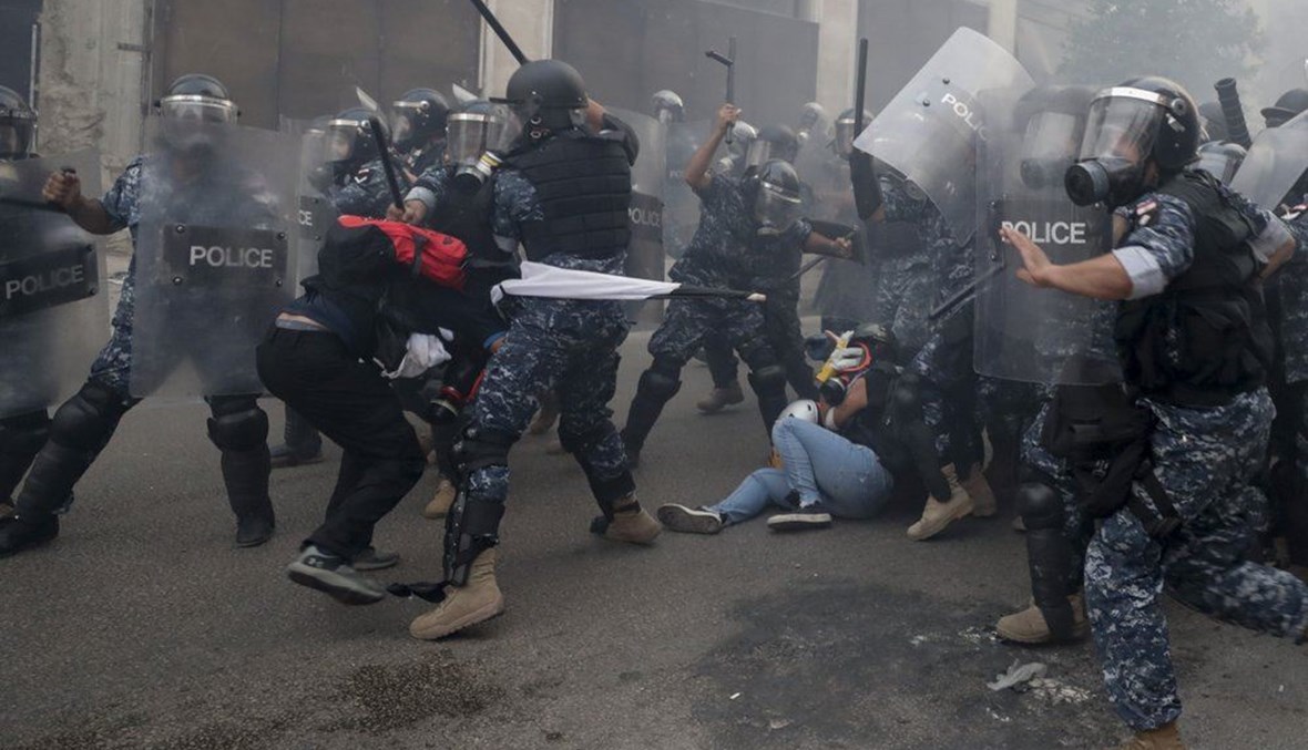 Riot policemen beat anti-government protesters during a protest near Parliament Square, in Beirut, Lebanon.