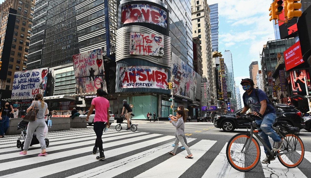 أشخاص يعبرون الشارع بالقرب من تايم سكوير في نيويورك (28 أيلول 2020، أ ف ب).  