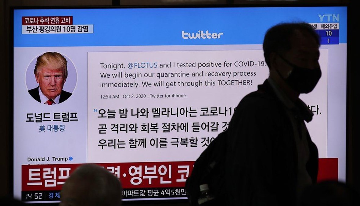 A man wearing a face mask walks near a TV screen showing an image of U.S. President Donald Trump's twitter during a news program at the Seoul Railway Station in Seoul, South Korea, Friday, Oct. 2, 2020. (AP Photo)