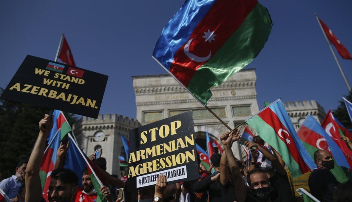 Demonstrators, holding Turkish and Azerbaijani flags, chant slogans during a protest supporting Azerbaijan, in Istanbul, Sunday, Oct. 4, 2020. (AP Photo)