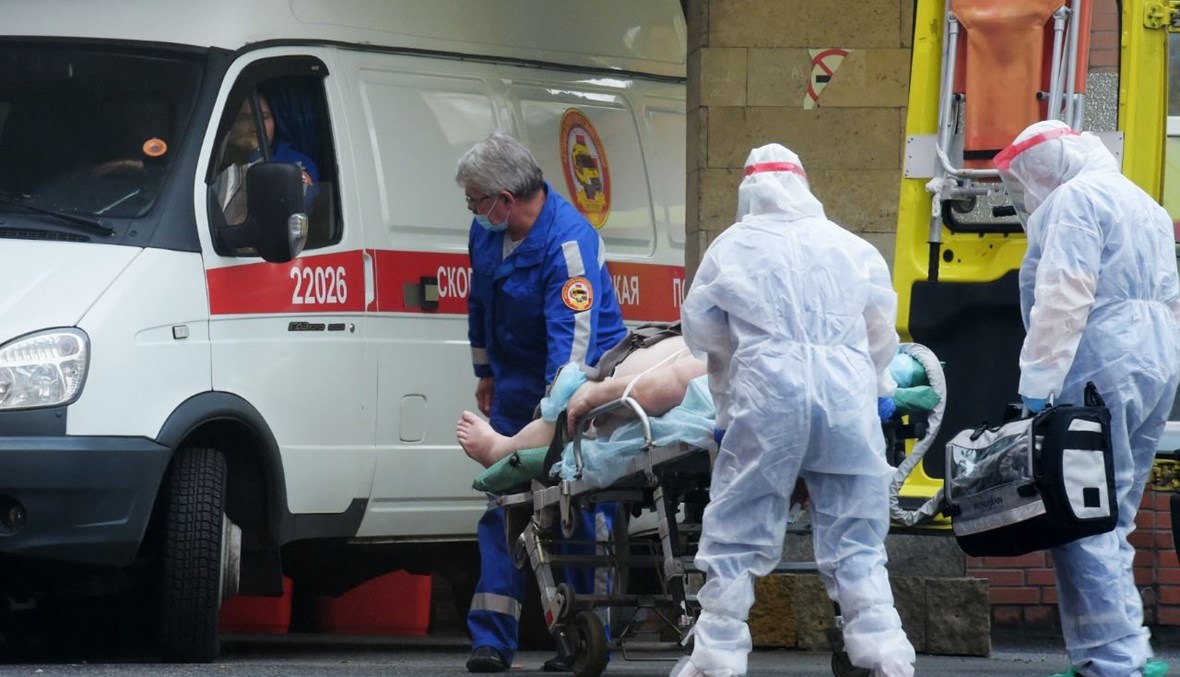 عمال صحيّون ينقلون مريضا إلى مستشفى بوكروفسكايا في سانت بطرسبرج (5 ت1 2020، أ ف ب). 