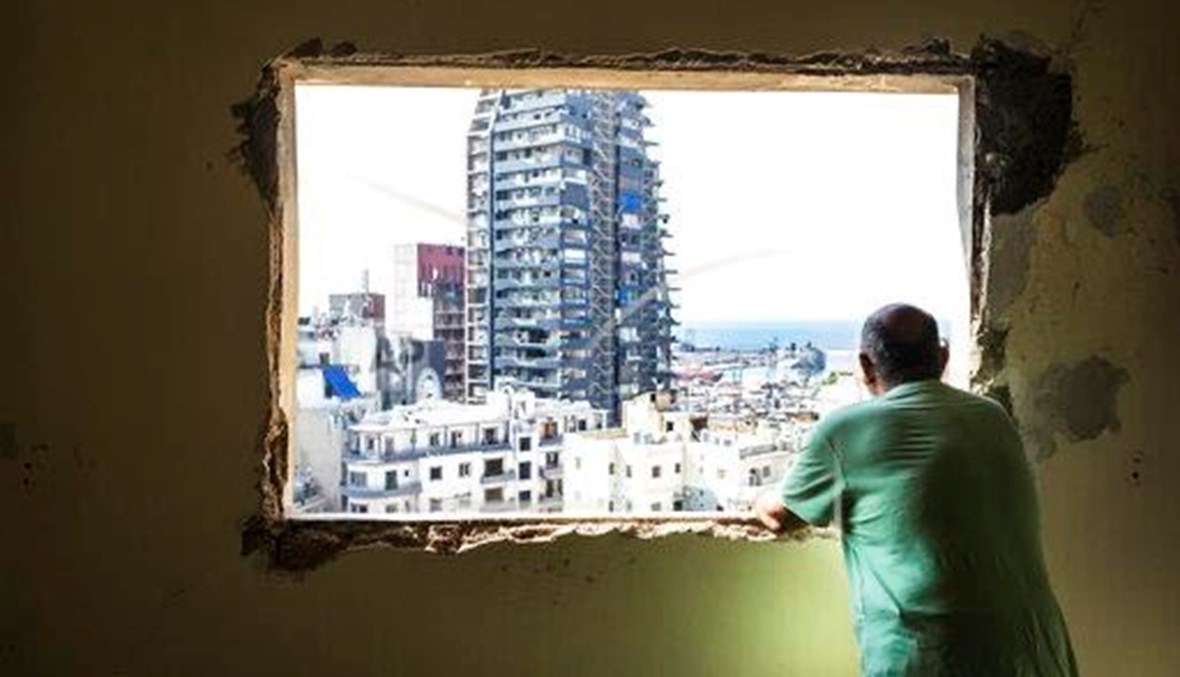 A Lebanese man gazes out of the window of his destroyed house upon Geitawi, one of the closest areas to the port explosion, August 28, 2020 (AP Photo)