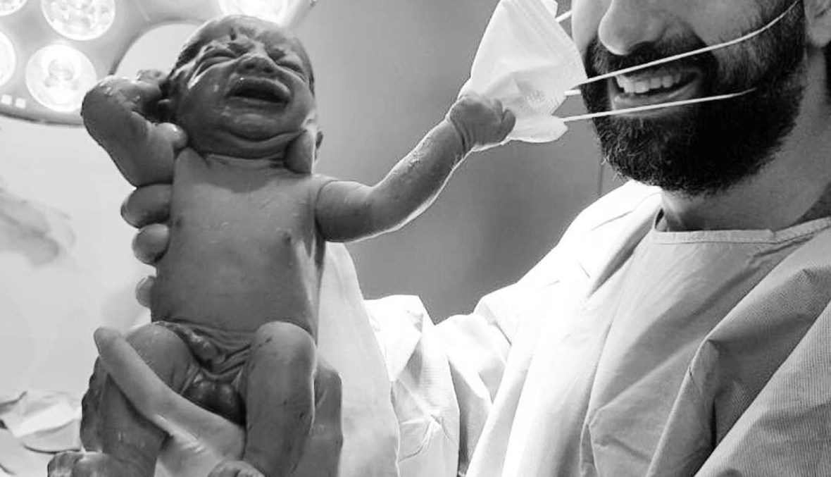 الدكتور سامر شعيب ومولود ينزع الكمامة. 