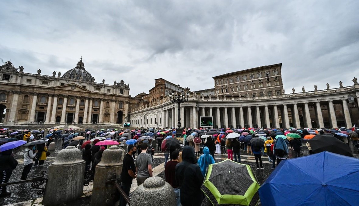 مؤمنون وقفوا تحت مظلات، فيما كان البابا فرنسيس يتكلم من نافذة القصر الرسولي المطل على ساحة القديس بطرس في الفاتيكان (11 ت1 2020، أ ف ب). 