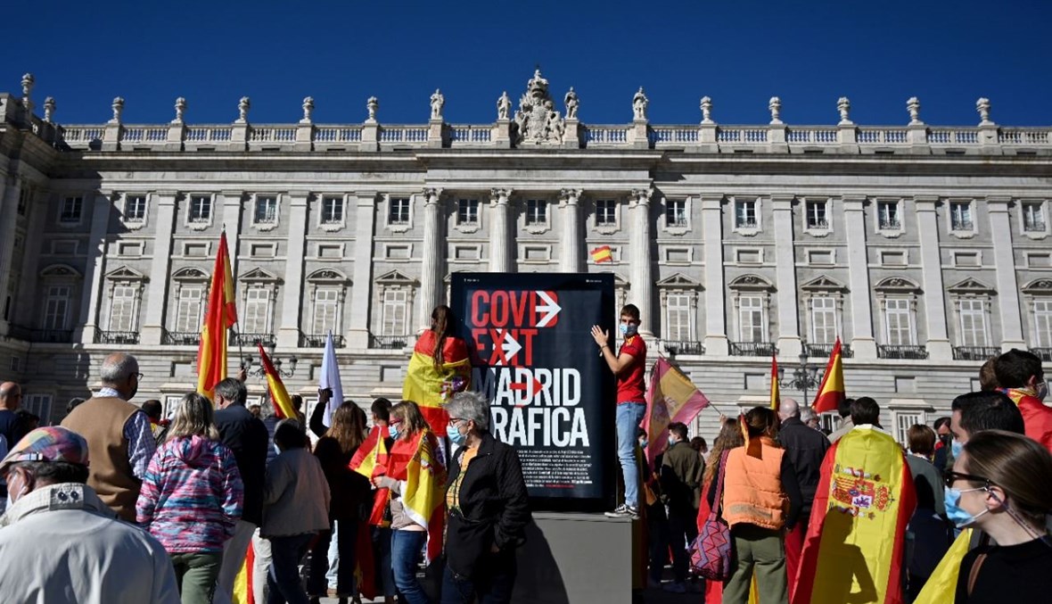 متظاهرون خارج القصر الملكي في مدريد، خلال احتجاج على إدارة الحكومة لأزمة كورونا (12 ت1 2020، أ ف ب). 