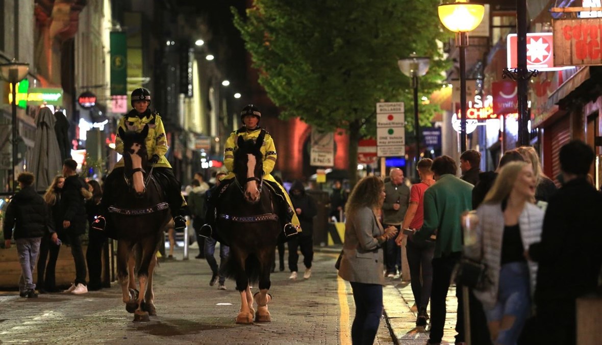 دورية للشرطة بين محتفلين وسط ليفربول شمال غرب إنكلترا (10 ت1 2020، أ ف ب). 