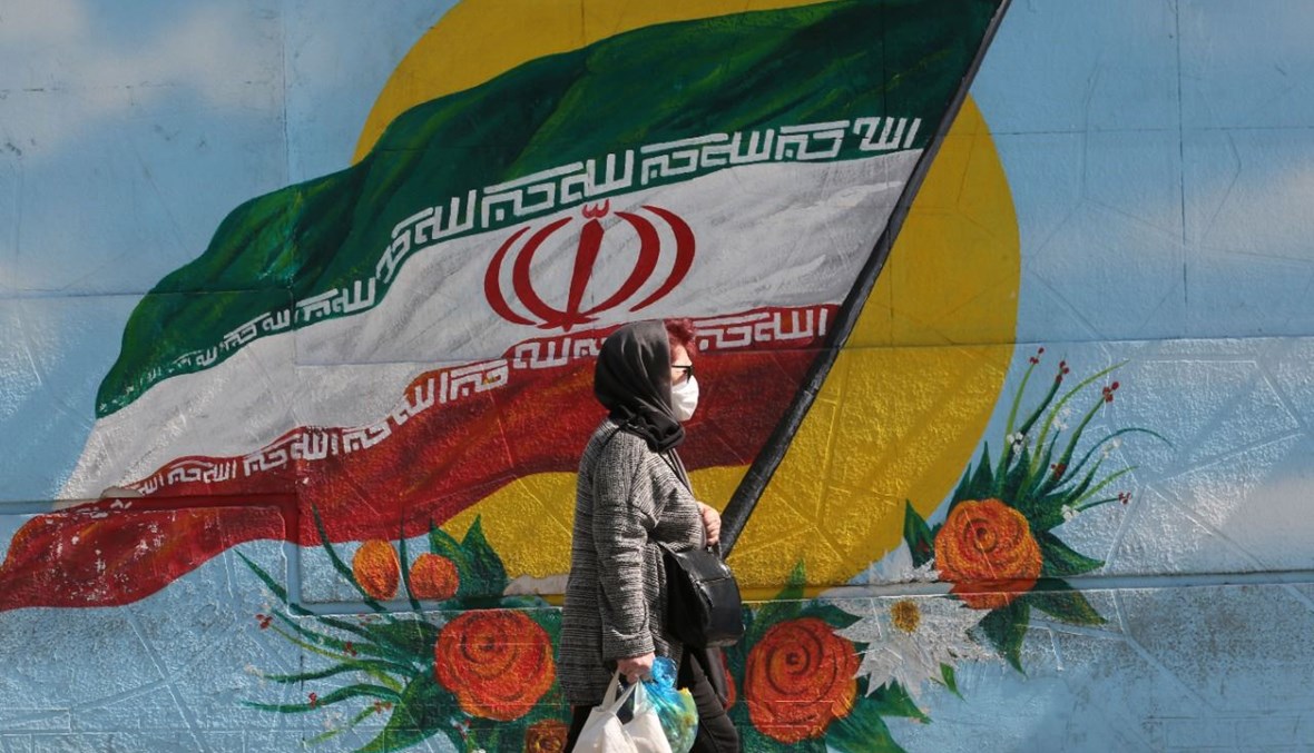امرأة تمشي في أحد الشوارع في طهران (14 ت1 2020، أ ف ب). 