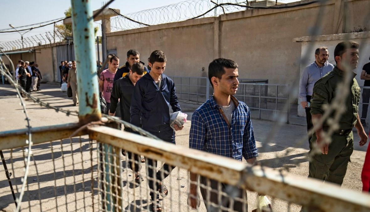 رجال يشتبه في تعاونهم مع داعش، يغادرون سجن علايا الذي يديره الأكراد في مدينة القامشلي شمال شرق سوريا (15 ت1 2020، أ ف ب). 