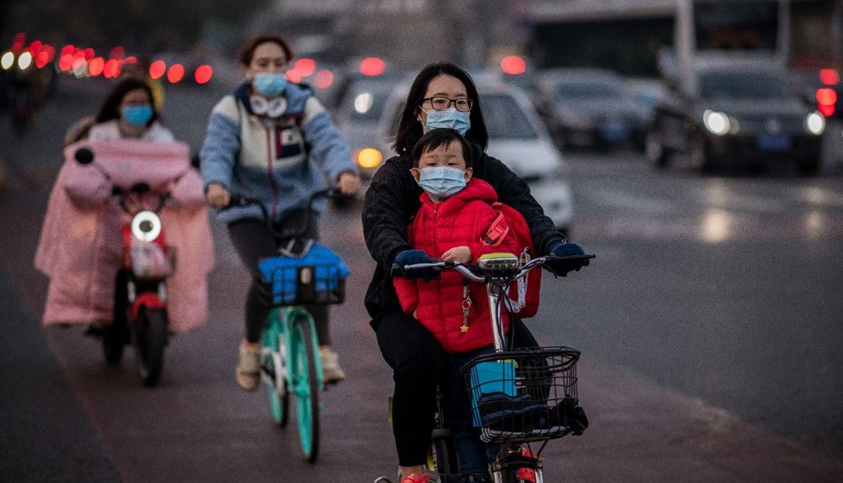 أشخاص يقودون دراجاتهم في بيجينغ خلال ساعة الذورة (15 ت1 2020، أ ف ب). 