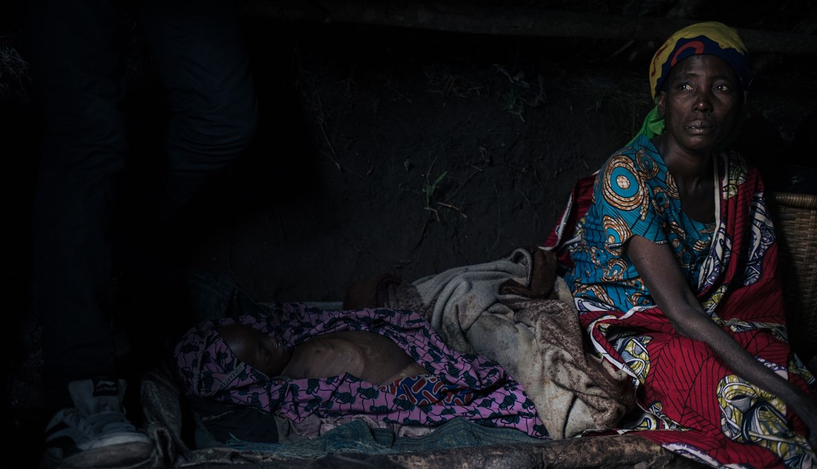 سيدة من الكونغو تبكي طفلتها "ريجينا" التي توفيت بسبب نقص الراعية الصحة (أ ف ب).