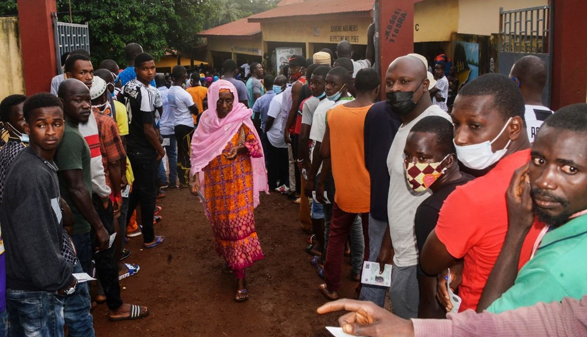 ناخبون ينتظرون في مركز اقتراع في كوناكري (18 ت1 2020، أ ف ب). 